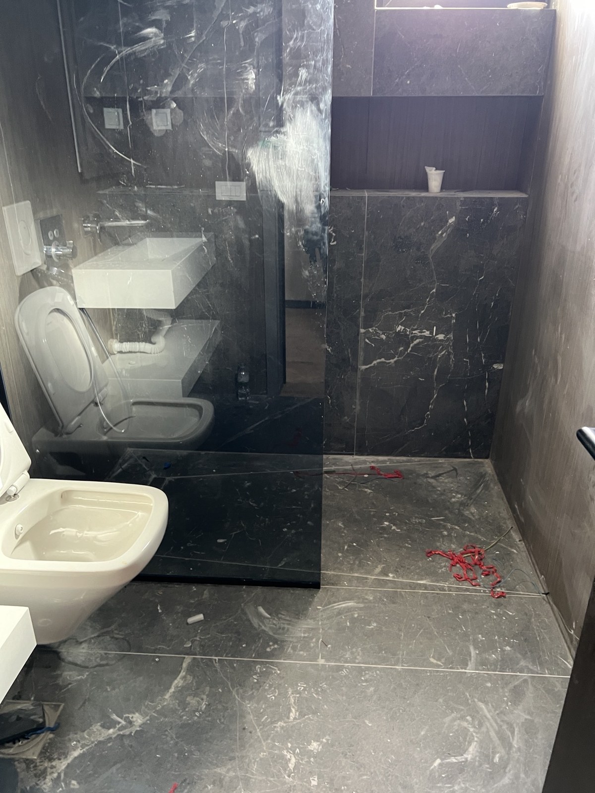 Dark marble bathroom before detailed cleaning